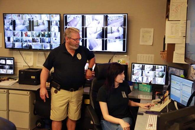 Maj. William Moseley looks over dispatcher Jessica Tipton's shoulder as they send out a test signal from the Tybee Island Police Department 911 Dispatch Center.