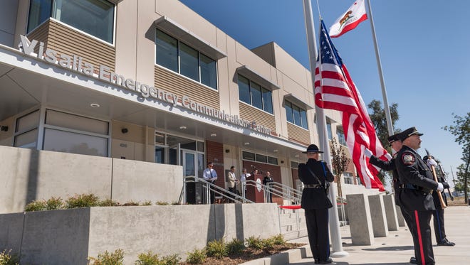The Visalia Police & Fire Honor Guard raises the flag on the City's new Emergency Communications Center on Wednesday, September 20, 2017 during the ribbon cutting ceremony. Council members are now considering Phase 2 of the Civic Center project, which has nearly tripled in cost to $70 million.
