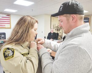 New Lapeer County Animal Control Chief Rachel Horton had her new badge pinned on by husband Ben at Thursday’s Board of Commissioners meeting. Horton is replacing Chief Dave Eady, who is retiring from the position at the end of this month. Photo by Krystal Moralee